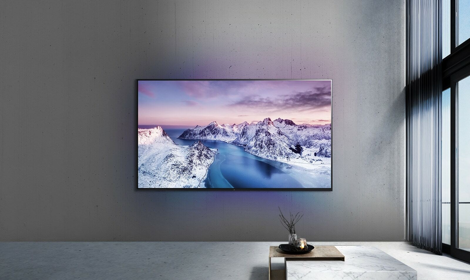 Un support TV UHD au mur derrière un tabe avec un décor de style zen.