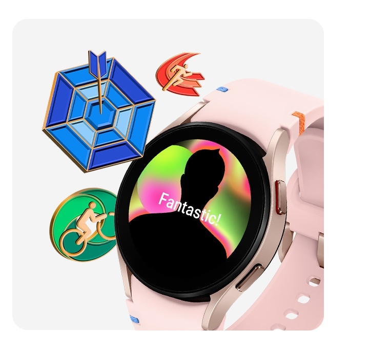 Une Galaxy Watch FE en or rose avec un bracelet à coutures roses est vue depuis le côté gauche incliné. Le cadran de la montre affiche un badge de récompense félicitant l'accomplissement de l'utilisateur. À gauche de la montre, il y a trois autres badges de récompense : un badge de course, une flèche frappant une cible et une personne sur un vélo.